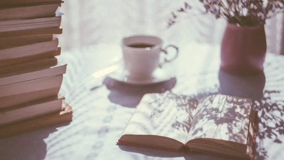 Neu anfangen bei der Partnersuche nach einer Trennung: eine Tasse Kaffee und ein offenes Buch am Fenster