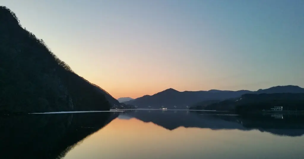 Partnersuche nach einer Trennung: ein ruhiger See zwischen Bergen in der Abenddämmerung